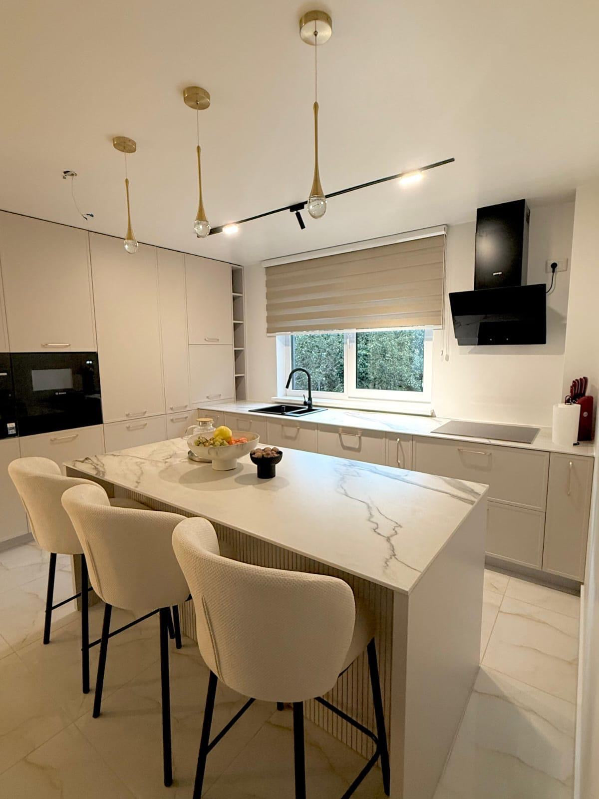 Modern kitchen with marble island and white chairs