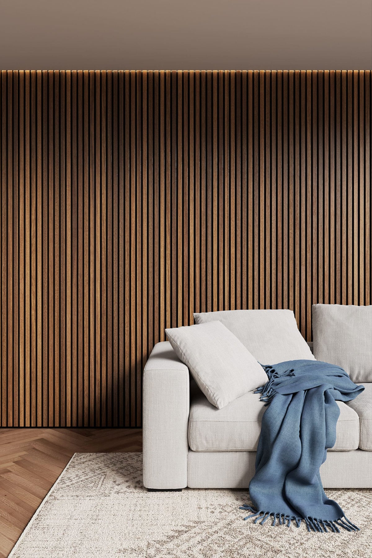 Gray sofa with a blue blanket against a wooden slat wall.